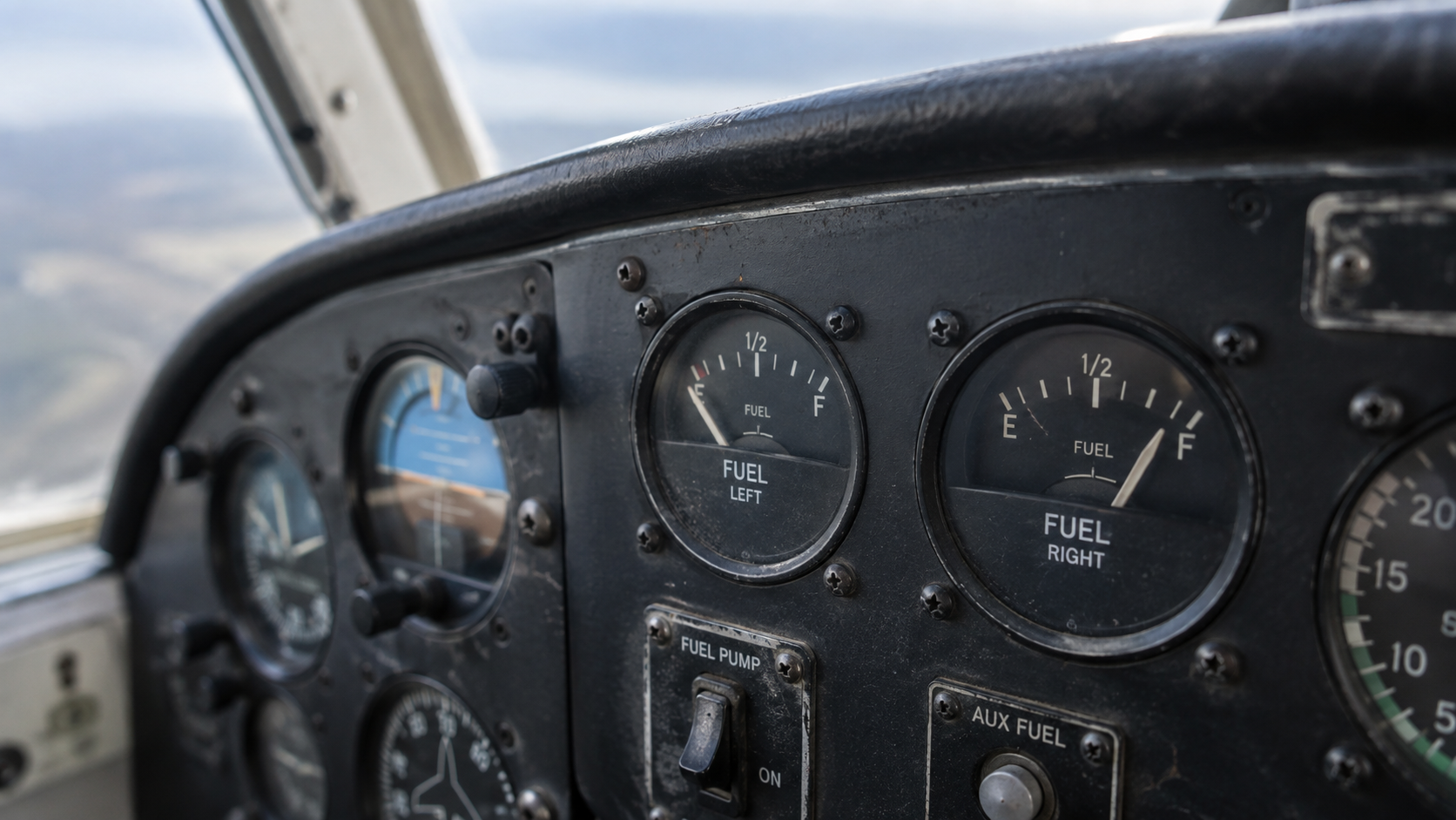 Aircraft cockpit fuel gauges showing left and right tank levels at half capacity during flight.